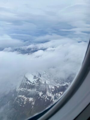 View of Icelandic snow-capped mountains from an airplane window.
