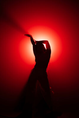 Cecilia's silhouette in front of a red, circular light.